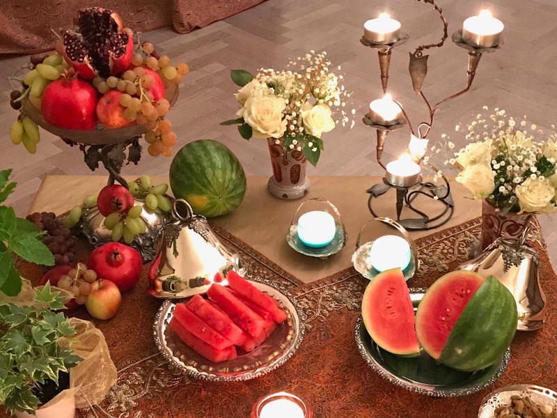 red fruits -whole and open pomegranates, and watermelons