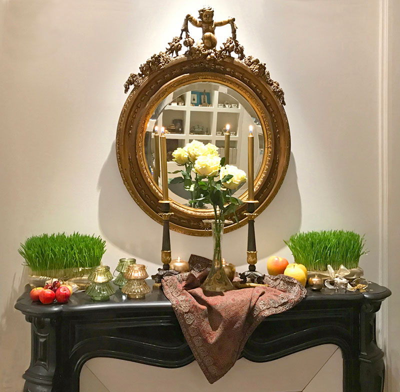 ornate mirror over a black marble mantelpiece