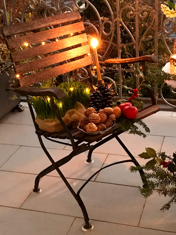 garden chairs featuring fresh sabzeh illuminated by Christmas tree lights