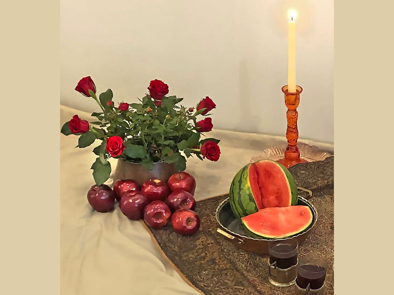 deep-red rose plant and Freedom cut roses, arranged in a traditional copper vessel