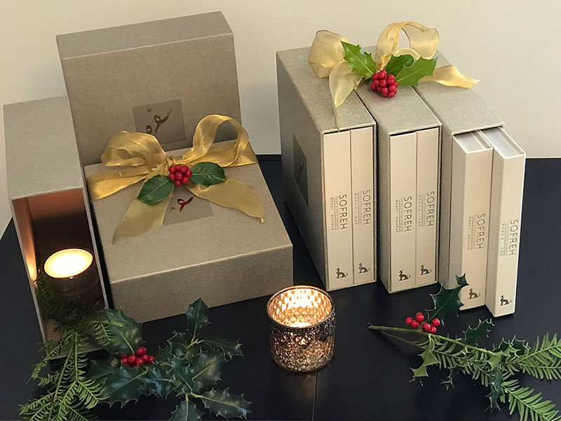 sofreh Christmas gift near holly and pine sprigs