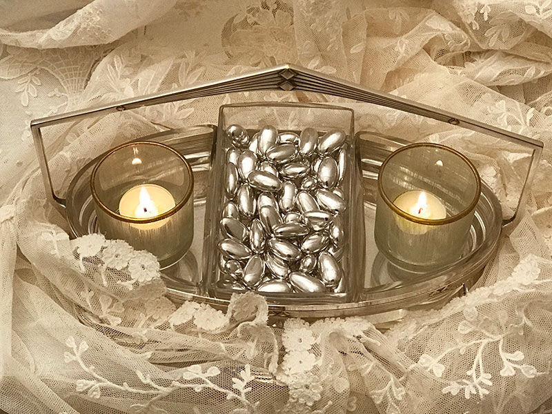 silver almonds and candles on lace