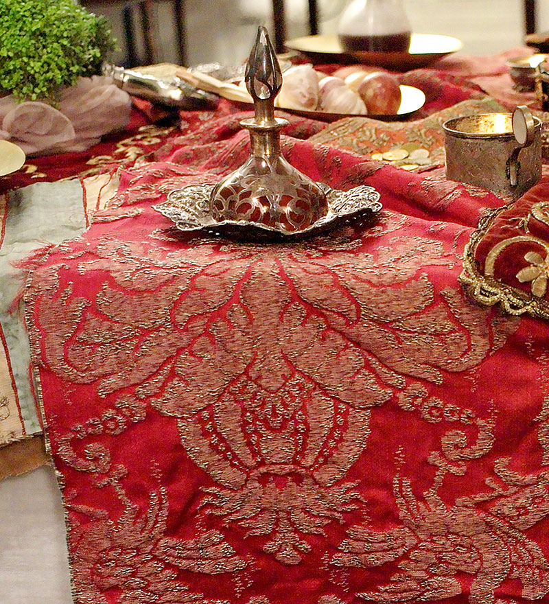 flask with rosewater on rich red textile