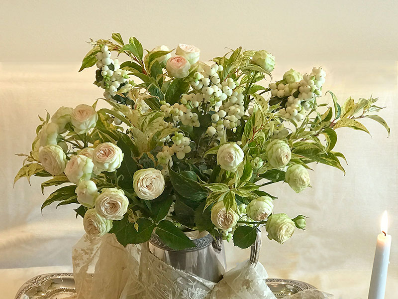 spray roses, snowberries, and variegated foliage