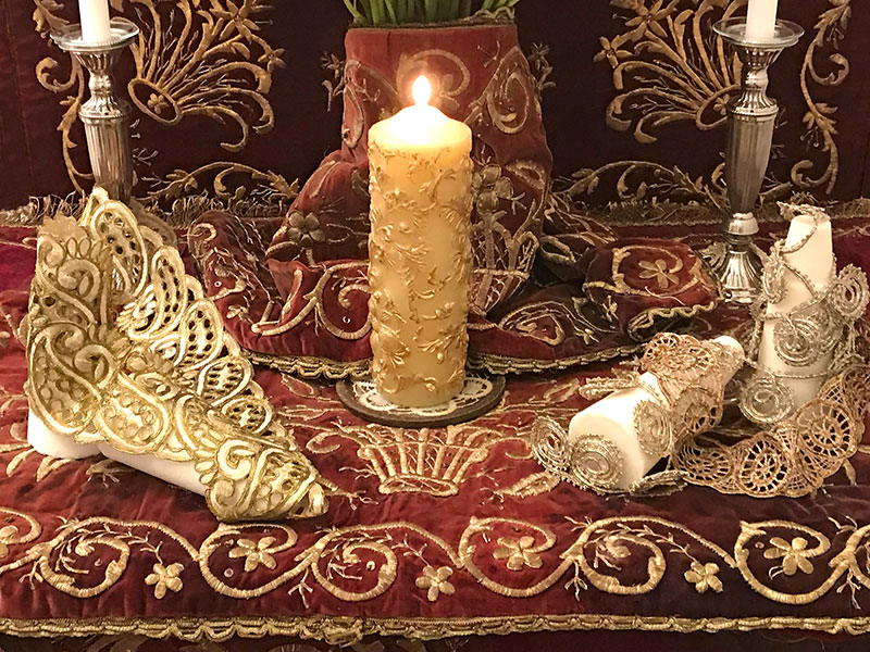 two pairs sugarloaves and candle on red velvet