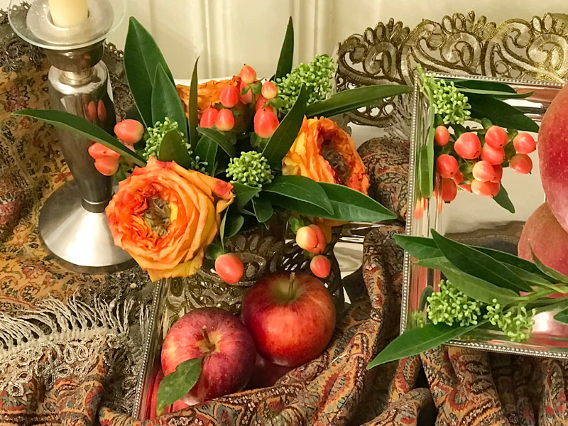 A dainty bouquet of deep-orange roses, known as Samoa, Skimmia and Hypericum