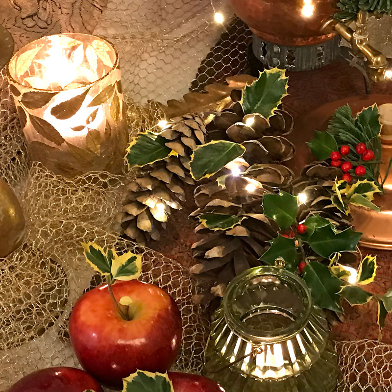 Oversized pine cones with sprigs and leaves of berried and variegated holly.