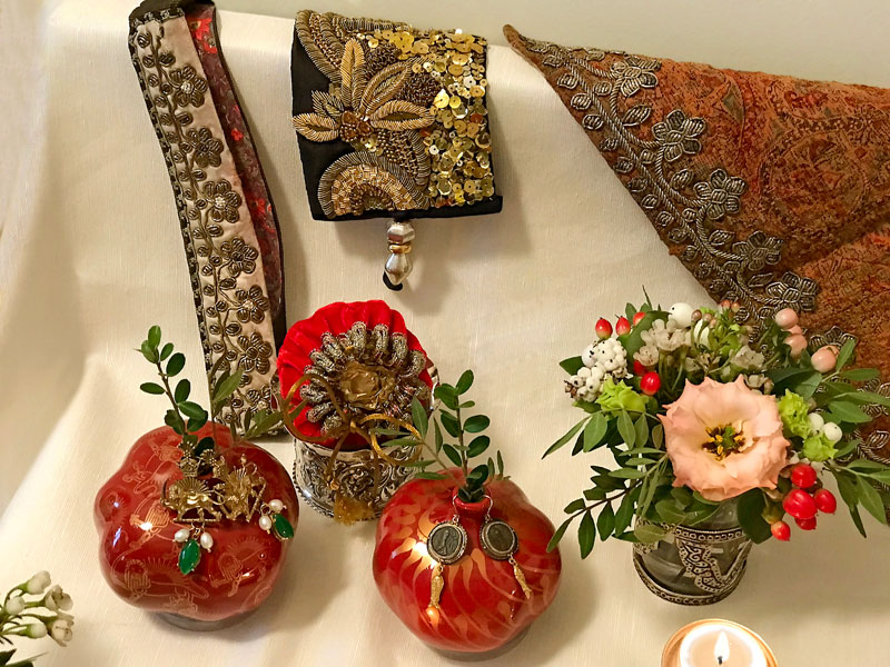 pairs of handmade earrings displayed on ceramic pomegranates