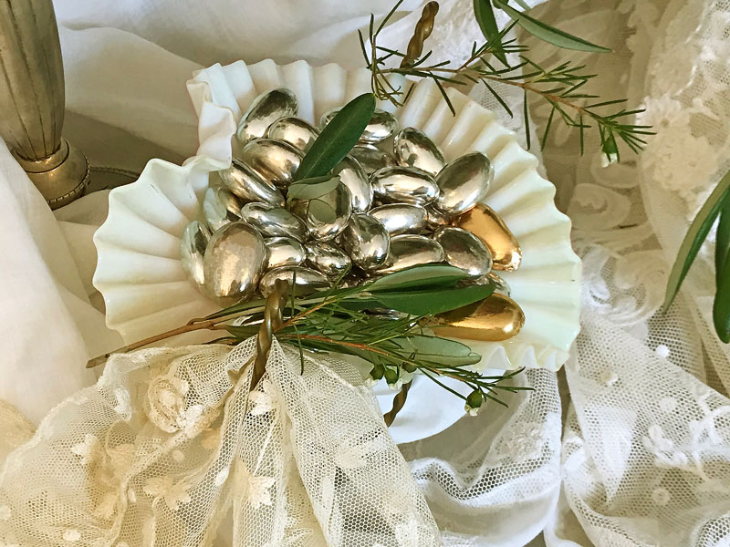 antique opaline vessel containing shiny silver- and gold-finish sugared almonds