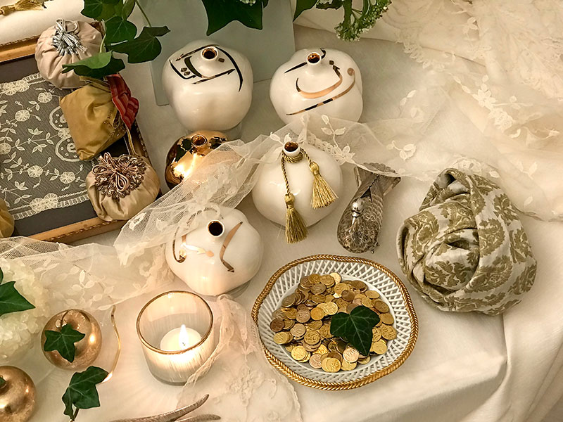ceramic pomegranates, gilded coins, silver bird, bonbonnieres and indian silk