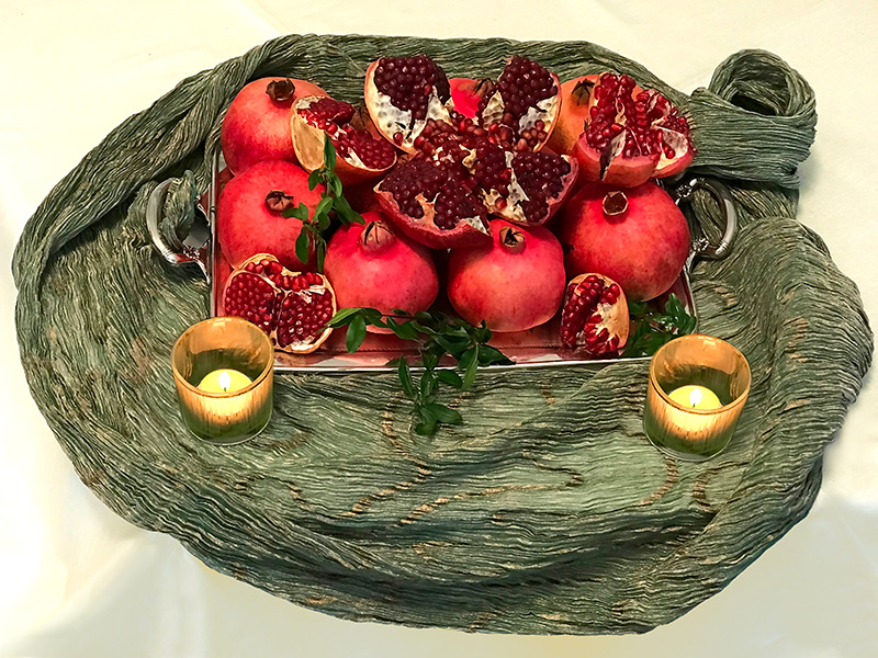 Open and whole pomegranates on Indian textile