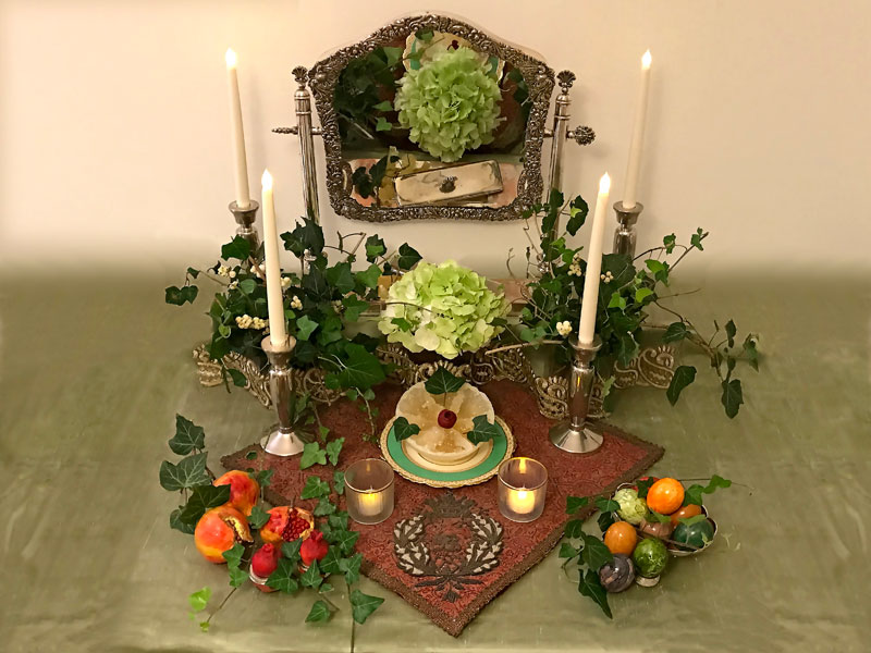 single green hydrangea, flanked by two vases of foliage