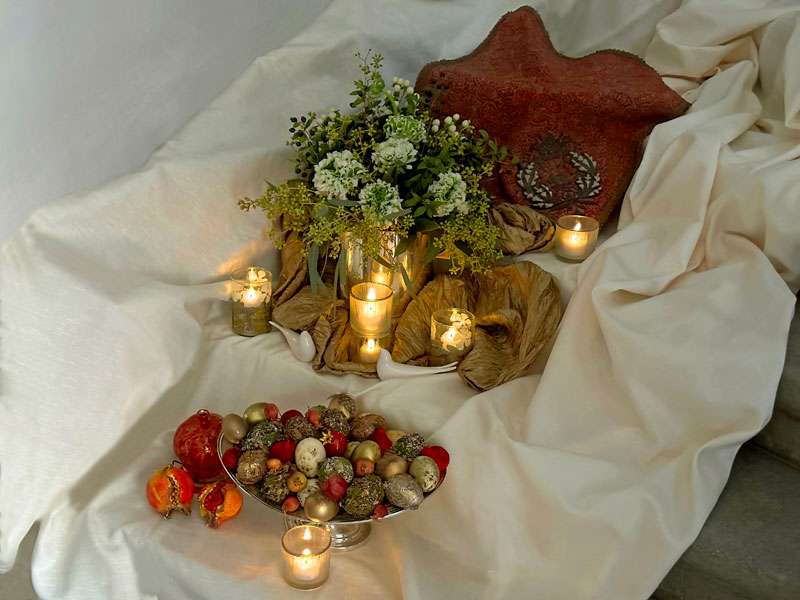 Flames, decorated eggs, sculptured pomegranates and a pair of stylized ceramic birds.