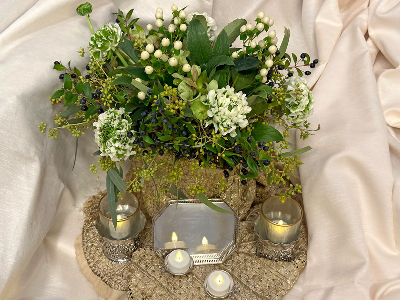 A splendid bouquet of Pompon Igloo ranunculi, Coco Uno Hypericums, Helleborus argutifolius, Eucalyptus exotica and Myrtus