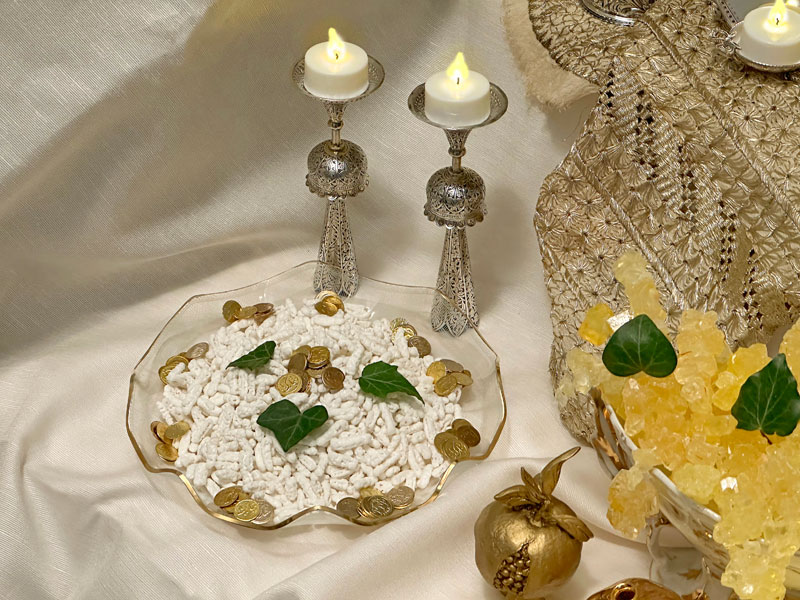 A delicate, gold-rimmed antique glass vessel contains the Persian sugared almonds