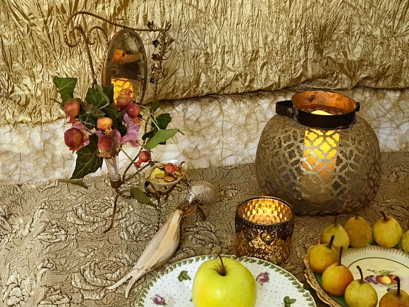 a bronze frame holding a mirror, an opaline vase showcasing ornamental pomegranates