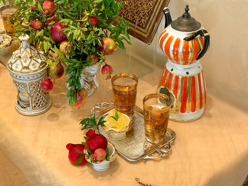 gold-rimmed glasses of tea together with Persian crystal sugar (nabat), placed on a miniature antique tray