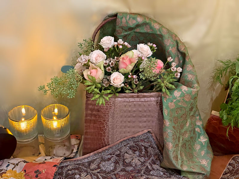vintage handbag houses a charming bouquet of small and spray roses in pastel shades