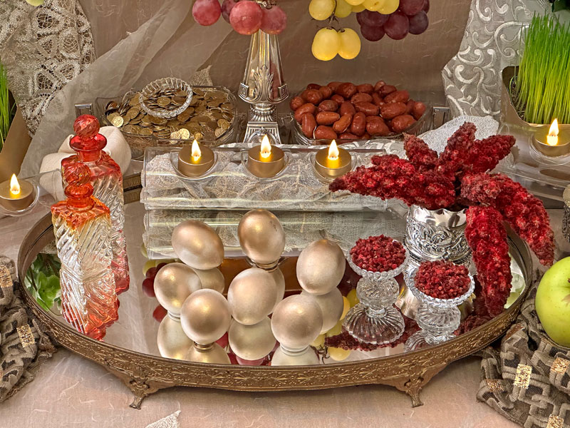 antique flasks of vinegar, sit atop an antique gold-framed mirrored tray