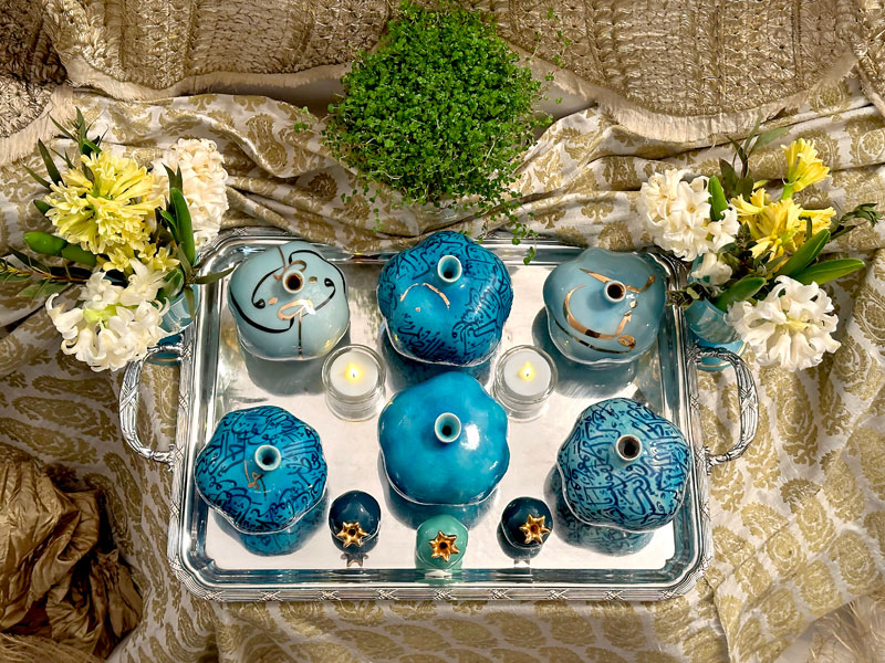 shiny silver-plated tray acts as a mirror and holds ceramic pomegranates of different sizes