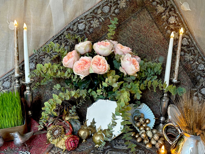 a mirror and candelabra with a bouquet of roses against the backdrop