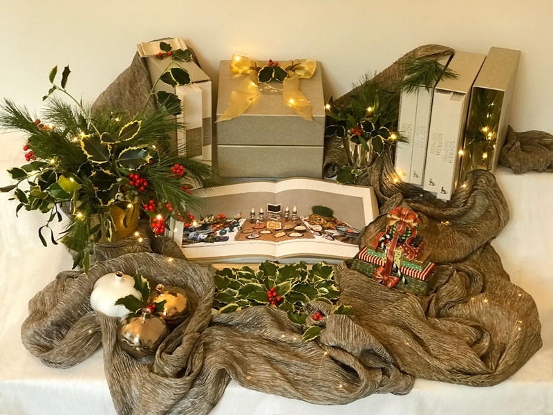 several volumes of the book with the inclusion of Christmas lights, and a variety of Christmas foliage